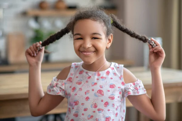 Χαριτωμένο κορίτσι με σγουρά μαλλιά με κοτσίδες που χαμογελάει όμορφα — Φωτογραφία Αρχείου