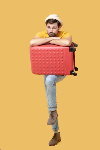 Sad bearded man in a hat with a suitcase — Stock Photo, Image