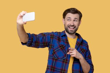 Neşeli suratsız adam akıllı telefondan selfie çekiyor..