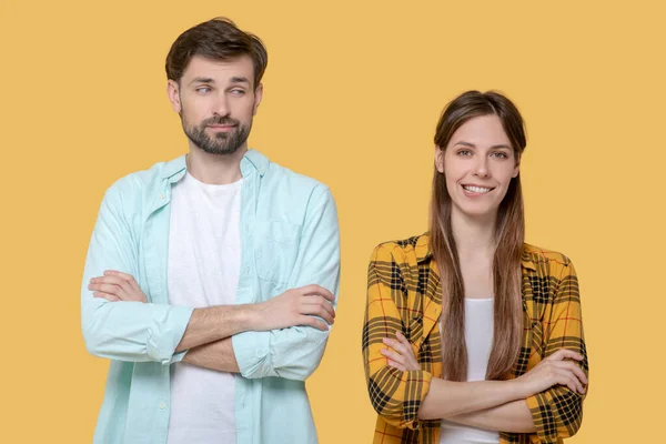 Cute young guy and girl standing in identical poses. — Stock Photo, Image