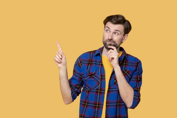 Young bearded man looking thoughtfully up and to the side — Stock Photo, Image