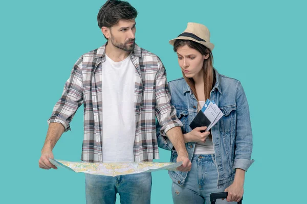 Young man with map girl with tickets and suitcase. — Stock Photo, Image