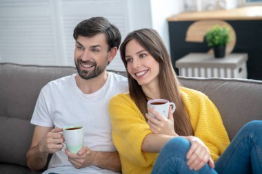 Ellerinde fincanlar olan mutlu adam ve kız.