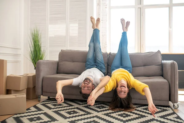 Homem e menina deitados no sofá levantando as pernas — Fotografia de Stock