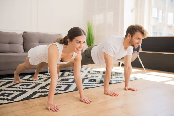 Pareja joven de pie en la tabla y buscando en forma — Foto de Stock