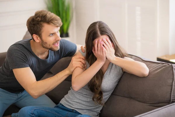 Jong baard man schreeuwen op zijn vrouw terwijl ze sluit haar gezicht en het gevoel bang — Stockfoto