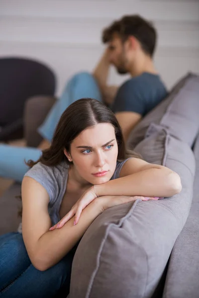 Mujer joven sentada con una mirada deprimida después de una mala charla con su marido — Foto de Stock