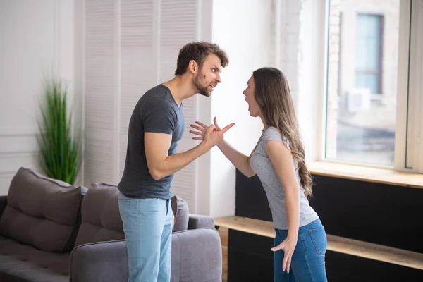 Young couple having a quarrel and shouting at each lother