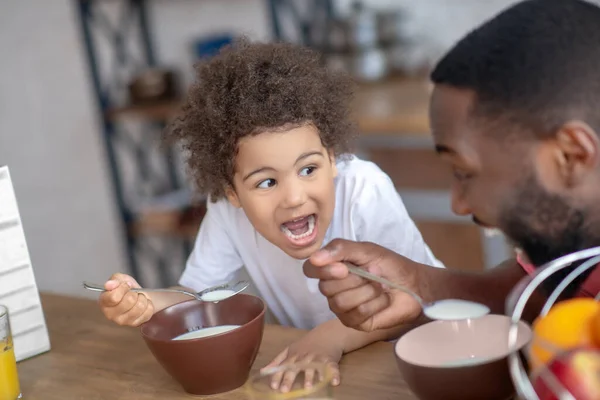 Süßes kleines Mädchen frühstückt mit ihrem Vater und ist aufgeregt — Stockfoto