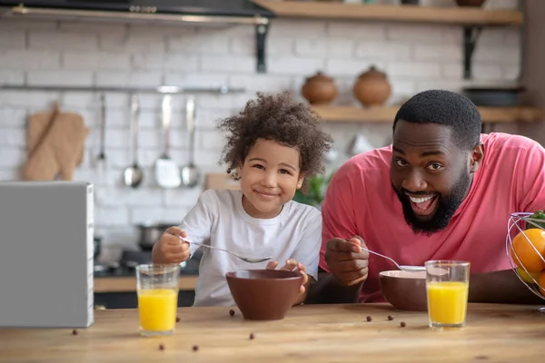 Süßes kleines Mädchen frühstückt mit ihrem Vater und fühlt sich wohl — Stockfoto