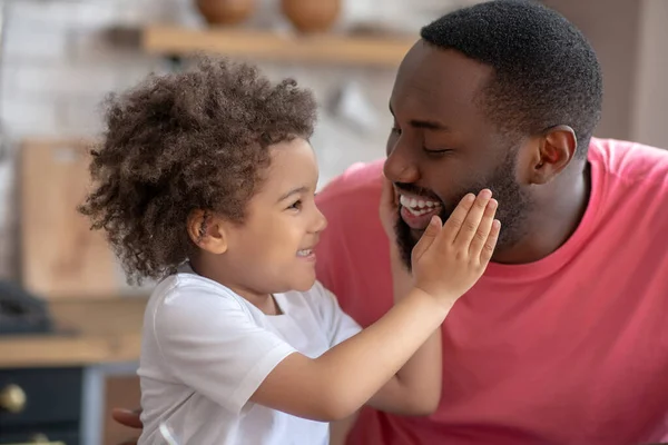 Lief klein meisje dat haar vaders gezicht aanraakt en lacht — Stockfoto