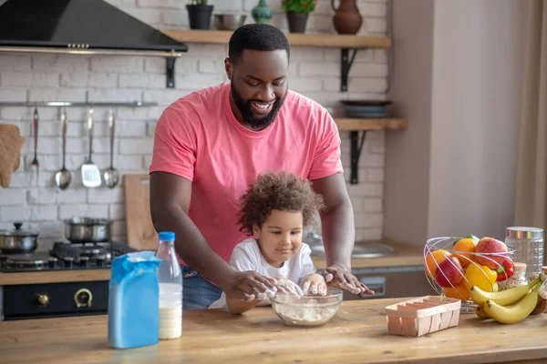 Lindo niño rizado y su padre jugando con harina en la cocina — Foto de Stock