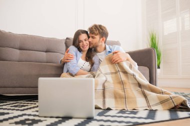 Genç mutlu çift ekoseli sigara içiyor ve film seyrediyor.