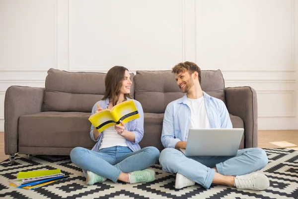 Молода пара сидить на підлозі, навчається разом і добре проводить час — стокове фото