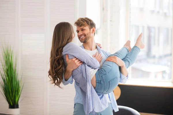 Ung man håller sin fru och känner sig lycklig — Stockfoto