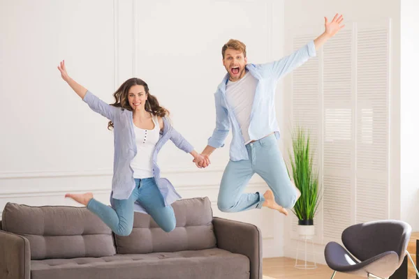 Молодая пара в джинсах прыгает и чувствует себя потрясающе — стоковое фото
