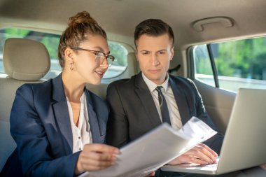 Gözlüklü bir kadın ve dizüstü bilgisayarlı bir adam..