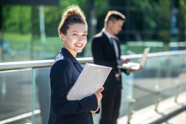 Evrakları sokakta duran parlak, sevimli kız..