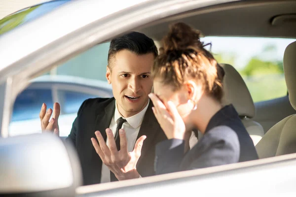 Homem de negócios sério e mulher chorando em um carro — Fotografia de Stock