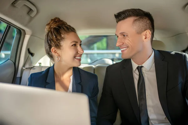 Homem atraente e mulher bonita olhando um para o outro no carro — Fotografia de Stock