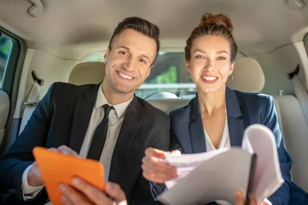 Homem e mulher bem-sucedidos e confiantes sentados no carro — Fotografia de Stock