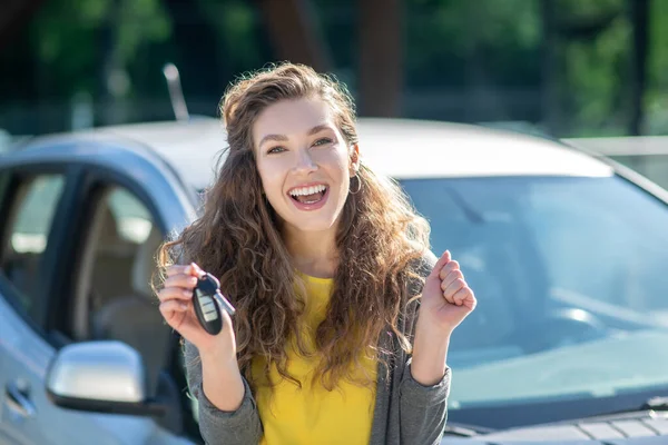 Bonito jovem segurando as chaves de um carro novo e se sentindo incrível — Fotografia de Stock