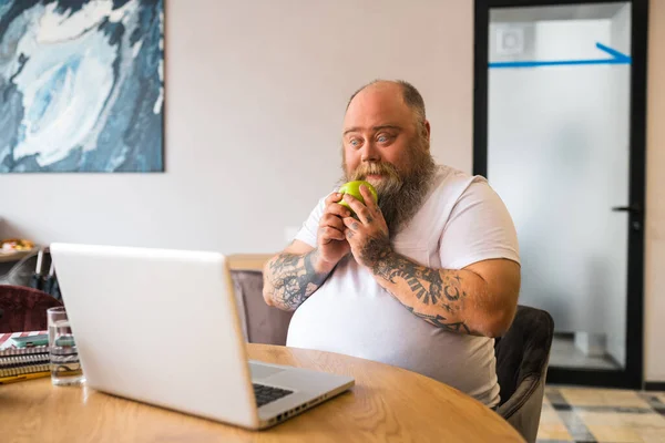 Bald bearded man in white tshirt holding an apple — Stock Photo, Image