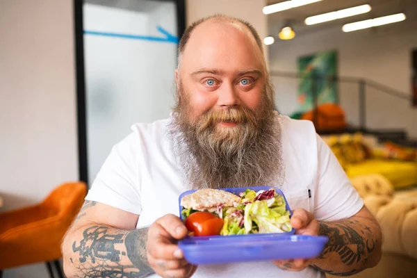 Calvo barbudo hombre de ojos azules en camiseta blanca comiendo su luhcn —  Fotos de Stock