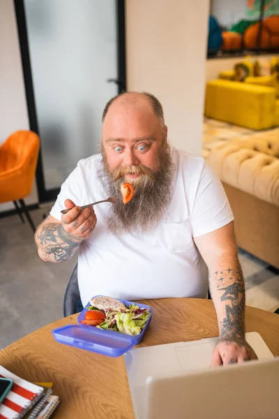 Kale baardman in wit tshirt met witte baard die zijn maaltijd eet — Stockfoto