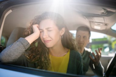 Upset woman in a car and a man. clipart