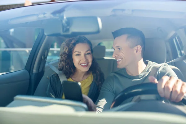 Homem olhando para uma mulher, ambos sentados em um carro — Fotografia de Stock