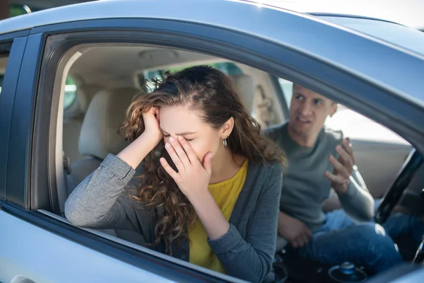 Femme en pleurs et homme en colère assis dans une voiture — Photo