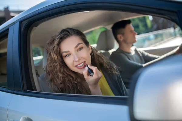 Woman with lipstick in peeking out of car — Stock Photo, Image