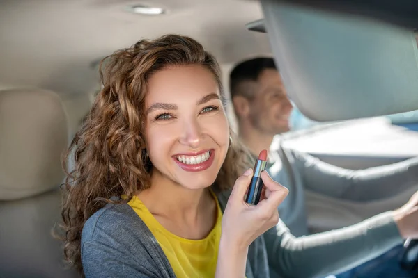 Feliz mulher sorridente com batom no carro — Fotografia de Stock