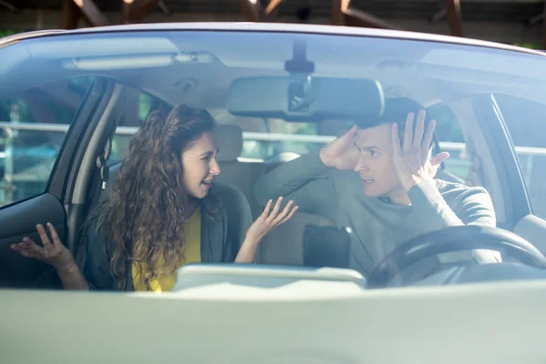 Mladý muž a žena třídění vztahy v autě — Stock fotografie