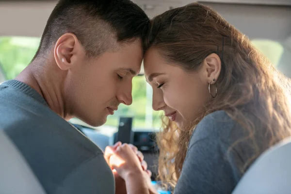 Amar a la joven y el hombre con los ojos cerrados sentado en el coche —  Fotos de Stock