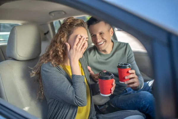 Homem e mulher com óculos de plástico nas mãos no carro — Fotografia de Stock