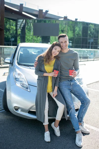 Jovem cara e menina de pé apoiando em um carro — Fotografia de Stock
