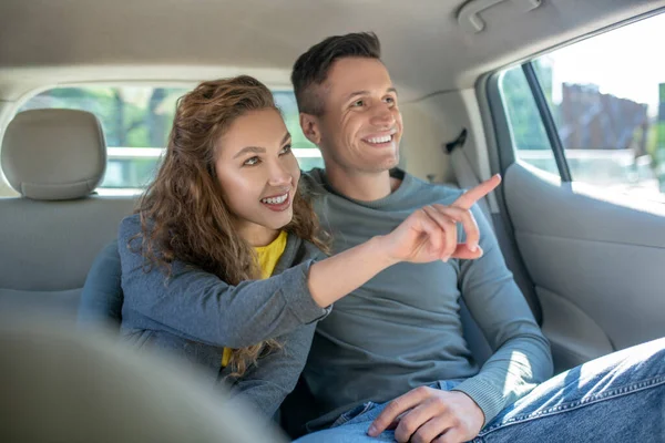 Жінка показує руку вікно і обіймає чоловіка в машині — стокове фото