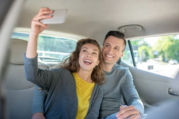 Frau macht Selfie mit Mann im Auto — Stockfoto
