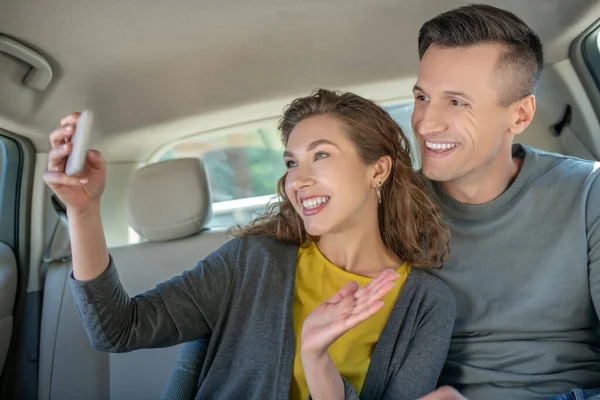 Mulher com smartphone e homem no carro — Fotografia de Stock