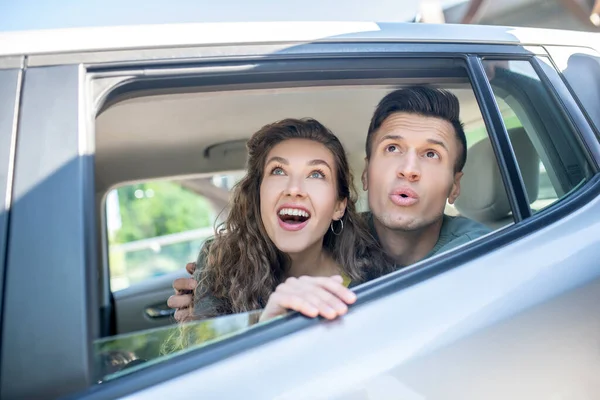 Άντρας και γυναίκα κοιτάζουν έξω από το παράθυρο του αυτοκινήτου — Φωτογραφία Αρχείου