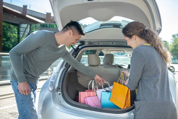 Homem e mulher perto do porta-malas aberto do carro — Fotografia de Stock