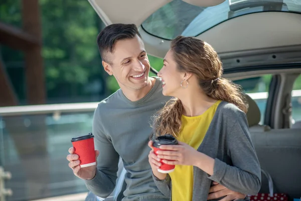 Amante homem e mulher bebendo café perto do carro . — Fotografia de Stock