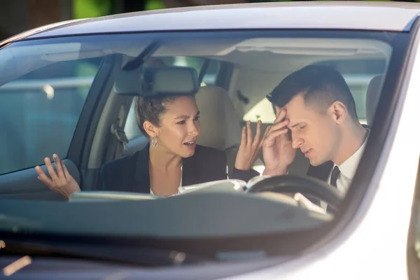 Obchodní žena a muž mluví vážně v autě — Stock fotografie