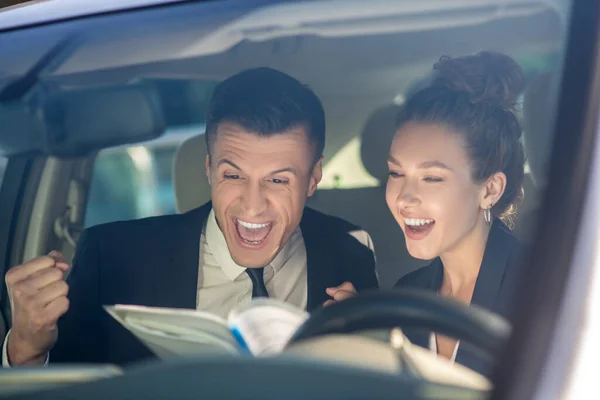 Muž a žena se radují, když sedí v autě — Stock fotografie