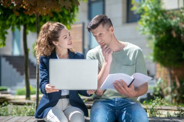 Tereddüt eden müşteriye kira için değişkenleri gösteren kadın simsar