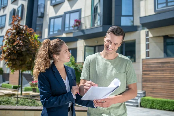 Vrouwelijke makelaar legt contractvoorwaarden uit aan de klant — Stockfoto