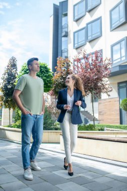 Zarif bir emlakçı müşterisiyle apartman dairesi hakkında konuşuyor.