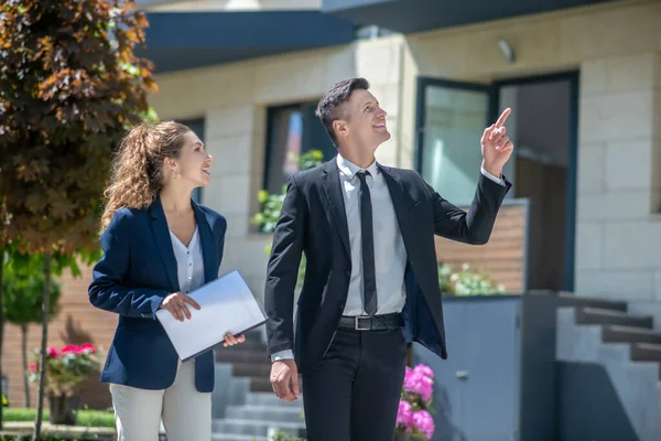 Cliente en un traje negro y un corredor discutiendo detalles del trato — Foto de Stock